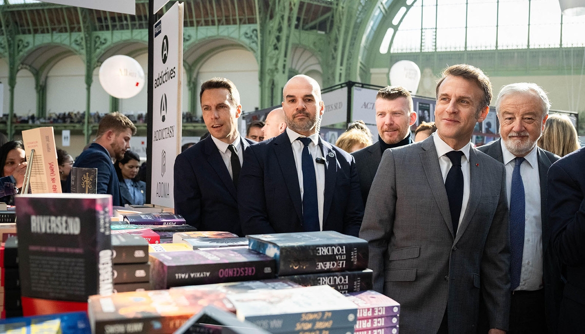 À côté du président Emmanuel Macron et de son service d'ordre, Vincent Montagne (à dr.), à la tête du groupe Média-Participations et président du Syndicat national de l'édition, lors du Festival du livre de Paris, le 11 avril 2025.