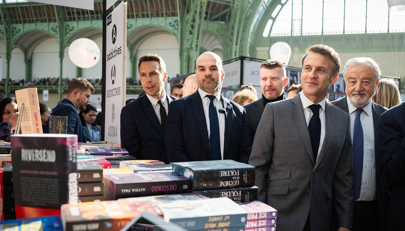 À côté du président Emmanuel Macron et de son service d'ordre, Vincent Montagne (à dr.), à la tête du groupe Média-Participations et président du Syndicat national de l'édition, lors du Festival du livre de Paris, le 11 avril 2025.
