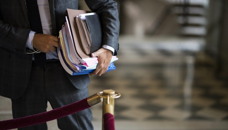 Un député chargé de dossiers dans la salle des Quatre-Colonnes à l'Assemblée nationale.