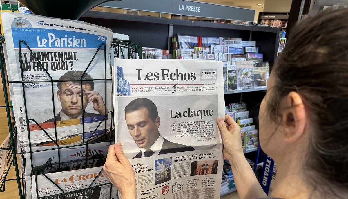 Des exemplaires du Parisien et des Échos chez un marchand de journaux.