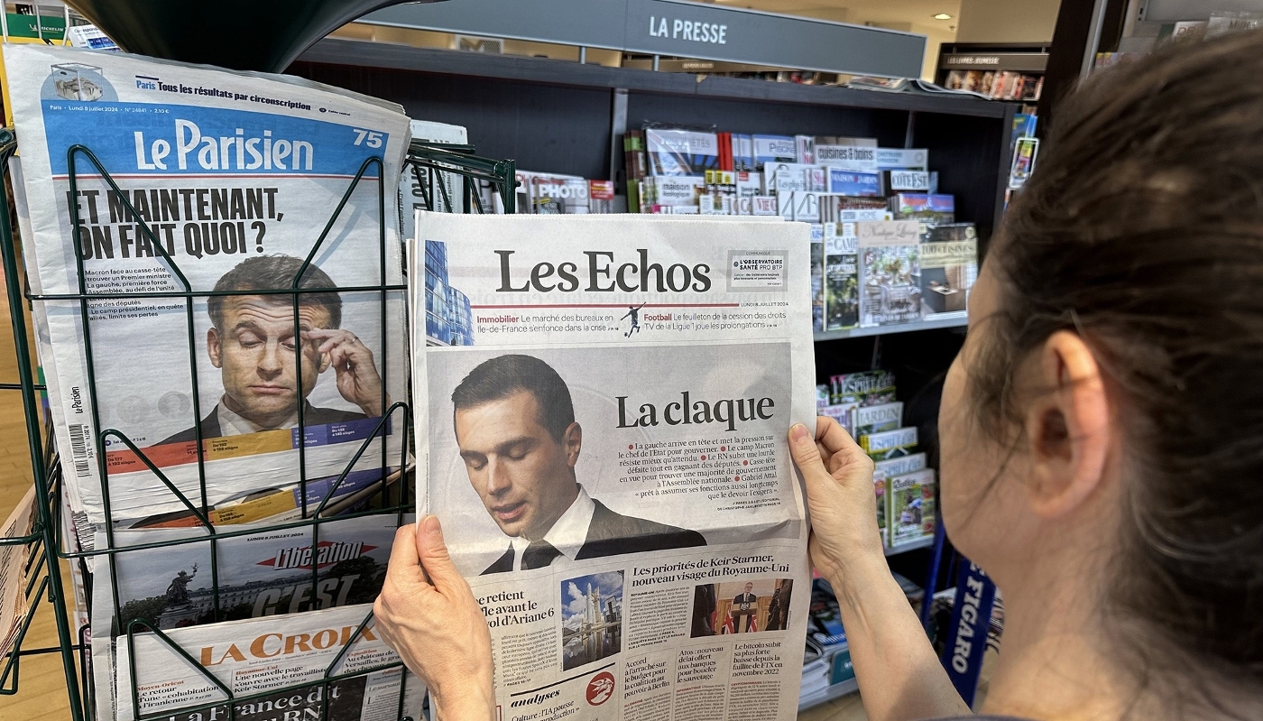 Des exemplaires du Parisien et des Échos chez un marchand de journaux.