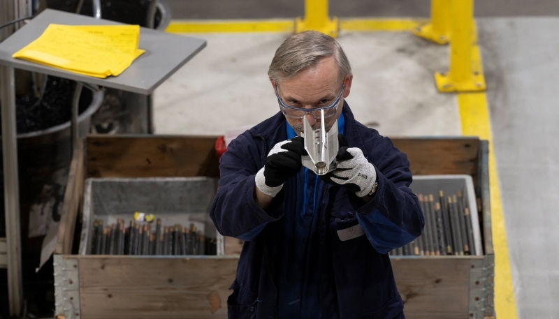 Un technicien inspectant une pièce d'un obus de 155 mm, dans l'usine belge de Petit-Rœulx-lez-Nivelles, en octobre 2023.
