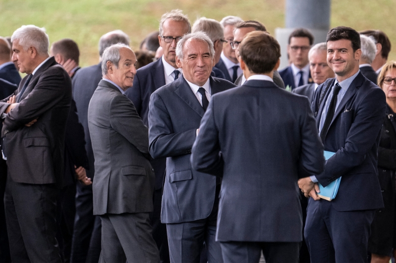 François Bayrou et David Djaïz, conseiller chargé du Conseil national de la refondation (CNR), entourent Emmanuel Macron (de dos), lors du lancement du CNR à Marcoussis (Essonne), le 8 septembre 2022.